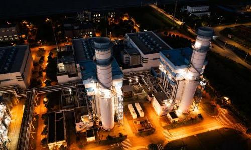 Two smokestacks at night. 